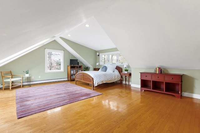 unfurnished bedroom featuring lofted ceiling, multiple windows, baseboards, and wood finished floors