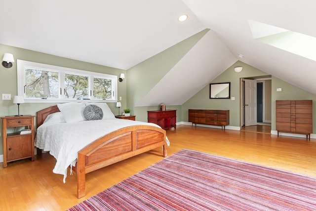 bedroom featuring lofted ceiling, wood finished floors, and baseboards