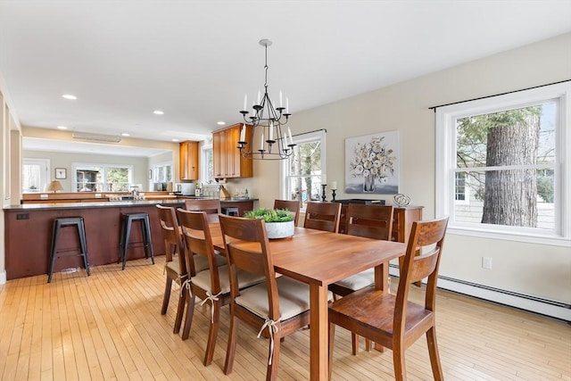 dining room with light wood-style floors, recessed lighting, and an inviting chandelier