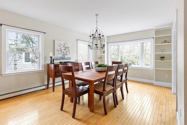 dining space with baseboards, an inviting chandelier, a baseboard radiator, and light wood-style floors