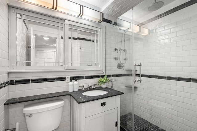 151 Tremont St Unit 8S, Boston, MA 02111 - bathroom with toilet, tile walls, a shower stall, and vanity