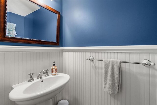 bathroom featuring a sink and a wainscoted wall