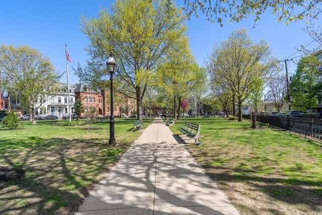 view of community featuring a yard and fence