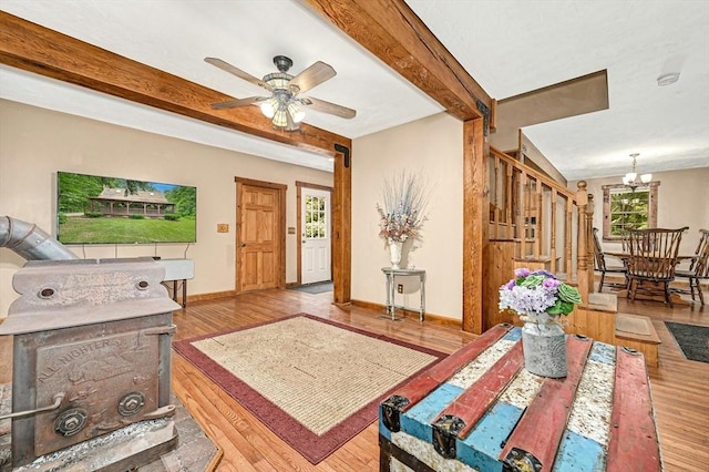 living room featuring beam ceiling, ceiling fan with notable chandelier, and light wood-type flooring