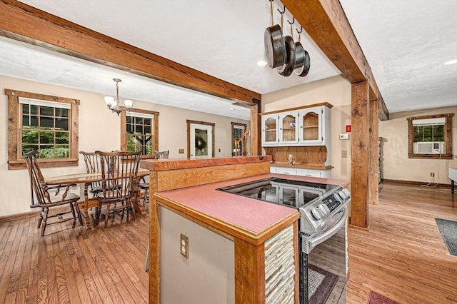 kitchen featuring beamed ceiling, stainless steel electric stove, light wood-type flooring, and kitchen peninsula