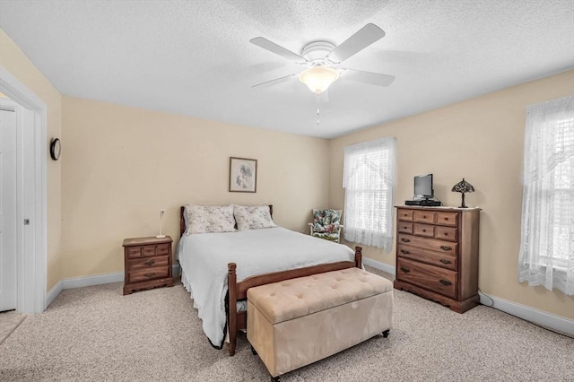 carpeted bedroom with ceiling fan and a textured ceiling