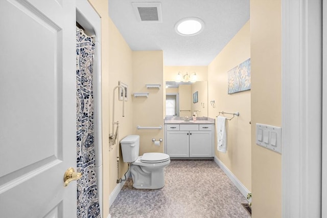 bathroom with vanity, toilet, and a textured ceiling