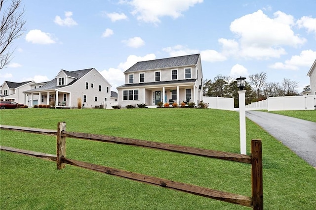 view of front of house featuring covered porch, a front yard, and fence