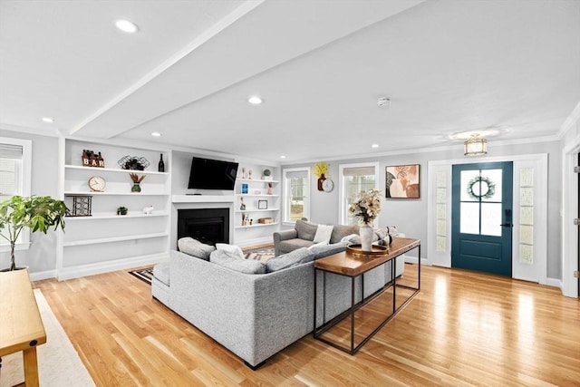 living area with crown molding, a fireplace, baseboards, light wood-style floors, and recessed lighting