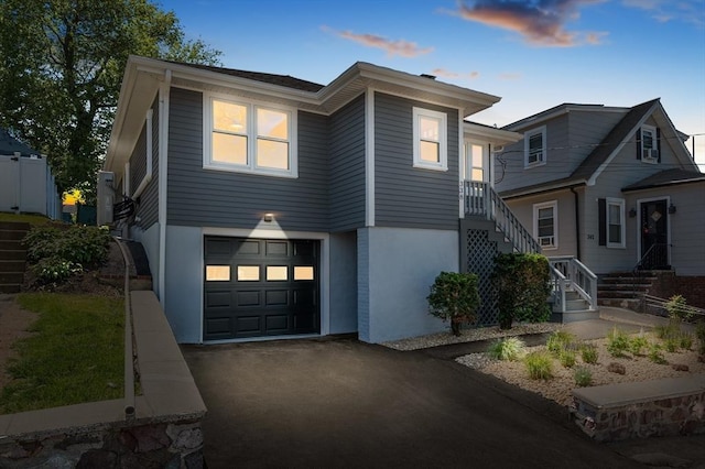 338 Vane St, Revere, MA 02151 - view of front of home featuring an attached garage, stairway, driveway, and stucco siding