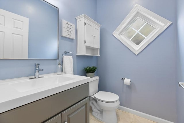 bathroom with baseboards, tile patterned flooring, vanity, and toilet