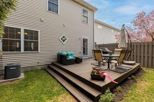 wooden terrace featuring outdoor dining area, central AC unit, and fence