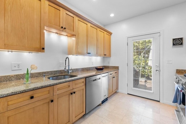 kitchen with a sink, baseboards, stone counters, stainless steel appliances, and recessed lighting