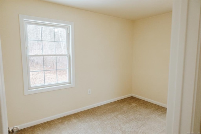 carpeted empty room featuring baseboards