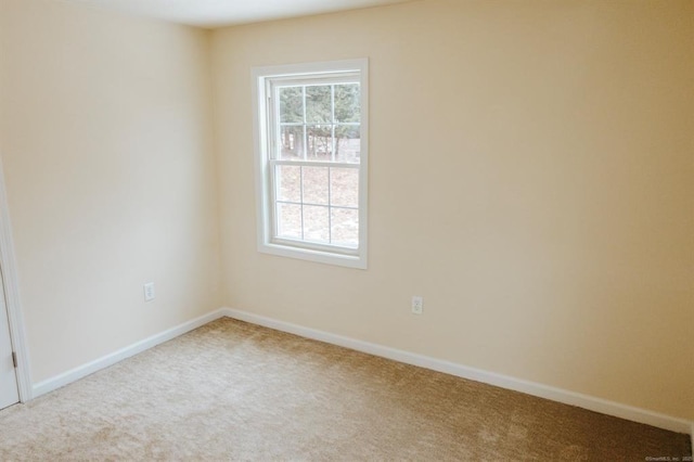 unfurnished room with carpet and baseboards