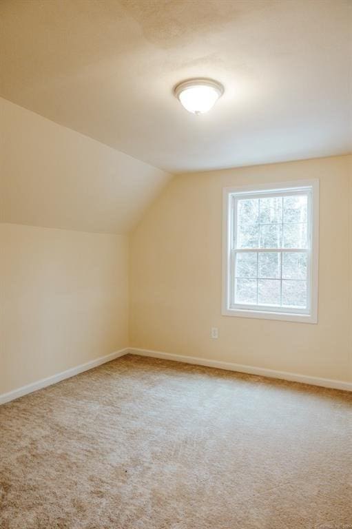 bonus room with vaulted ceiling, carpet, and baseboards