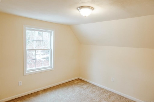 bonus room featuring lofted ceiling, carpet, and baseboards