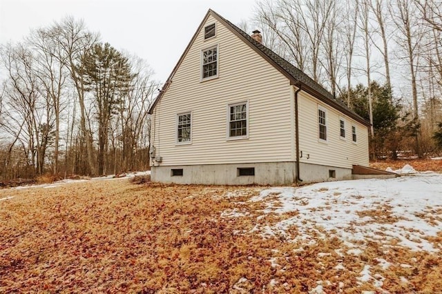 view of snow covered exterior with a chimney