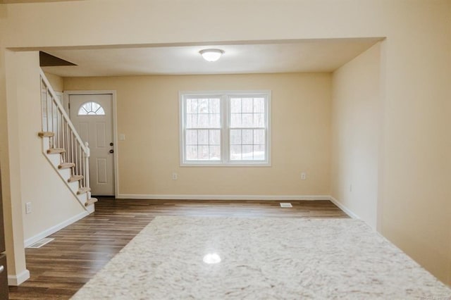 entrance foyer with visible vents, baseboards, dark wood-style flooring, and stairway