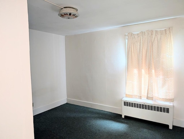 5 Hall St, Webster, MA 01570 - empty room with radiator, baseboards, and dark colored carpet