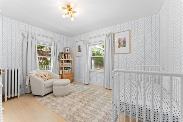 633 Lagrange St, Boston, MA 02132 - bedroom with radiator, wallpapered walls, wood finished floors, multiple windows, and a chandelier