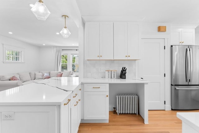 633 Lagrange St, Boston, MA 02132 - kitchen with freestanding refrigerator, radiator, open floor plan, light countertops, and a peninsula