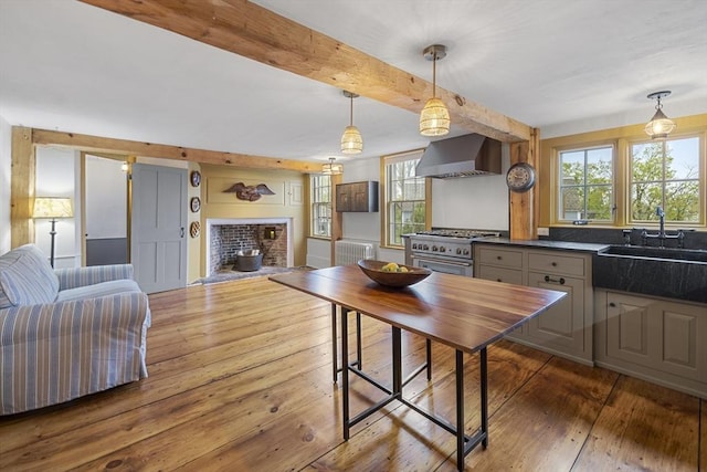 6 Lee St, Marblehead, MA 01945 - kitchen featuring wall chimney range hood, a sink, high end stainless steel range, dark countertops, and wood-type flooring