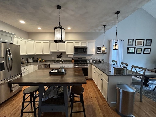 16 Jaclyns Way Unit 16, Billerica, MA 01862 - kitchen with stainless steel appliances, a peninsula, a sink, dark wood-type flooring, and pendant lighting