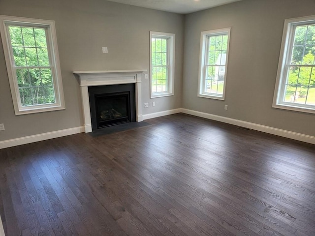 138 Elm St, Uxbridge, MA 01569 - unfurnished living room with dark wood-style flooring, baseboards, a fireplace with flush hearth, and plenty of natural light