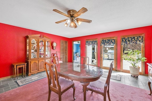 dining room featuring baseboards, a wealth of natural light, a textured ceiling, and ceiling fan