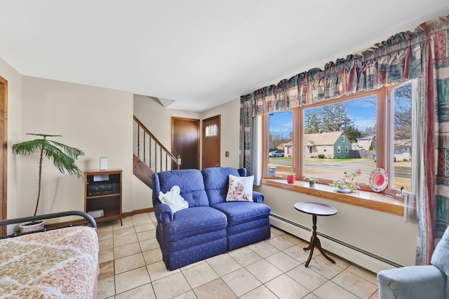 living room featuring baseboard heating, light tile patterned floors, baseboards, and stairway