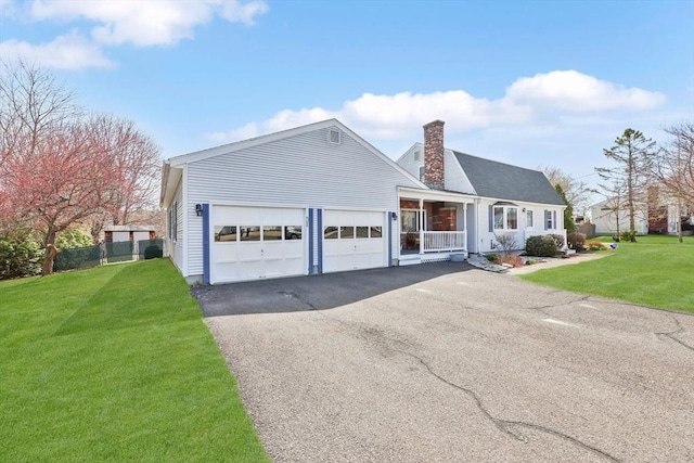 ranch-style house with a chimney, aphalt driveway, fence, a front lawn, and a garage