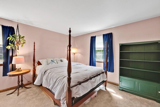 bedroom with baseboards and light colored carpet