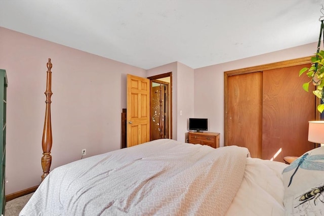 bedroom with baseboards, carpet floors, and a closet