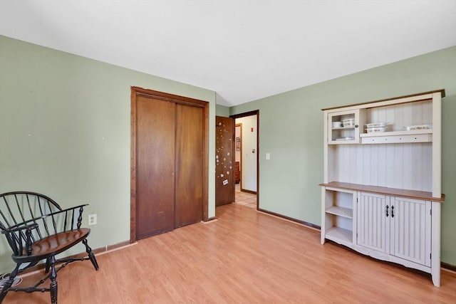 interior space with baseboards, a closet, and light wood-style flooring