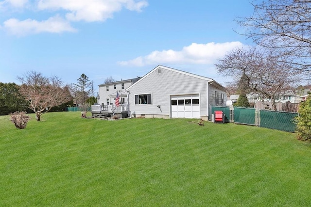 back of house with fence, a deck, a yard, and a garage