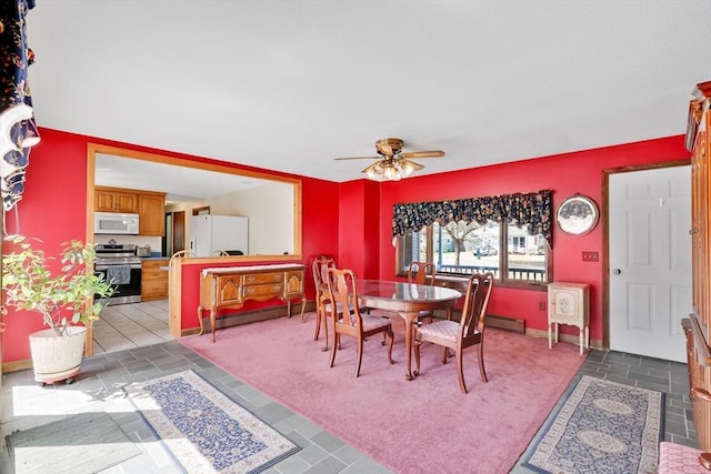 carpeted dining space featuring a baseboard radiator, a ceiling fan, and baseboards