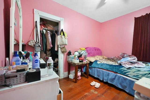 bedroom featuring wood-type flooring, ceiling fan, and a closet