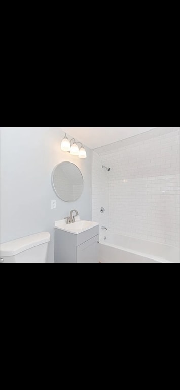 full bathroom with toilet, tiled shower / bath combo, and vanity