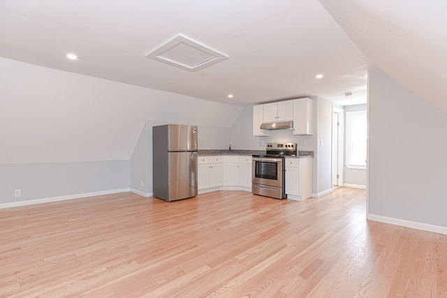 kitchen featuring white cabinets, stainless steel appliances, light hardwood / wood-style floors, and vaulted ceiling