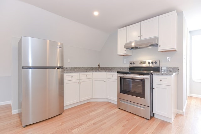 kitchen featuring stainless steel appliances, lofted ceiling, light stone counters, white cabinets, and light wood-type flooring