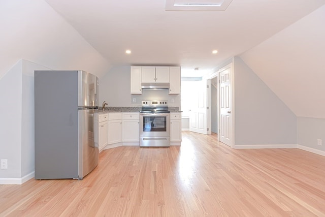 kitchen with white cabinets, stainless steel appliances, vaulted ceiling, and light hardwood / wood-style flooring