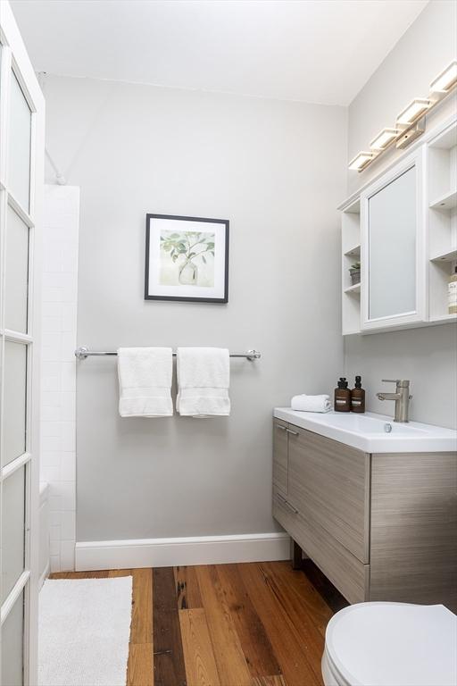 126 Amory St Unit B4, Brookline, MA 02446 - full bath featuring vanity, toilet, wood finished floors, and baseboards