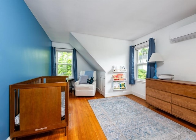 136 Walnut St, Braintree, MA 02184 - bedroom featuring a wall unit AC, vaulted ceiling, and wood finished floors