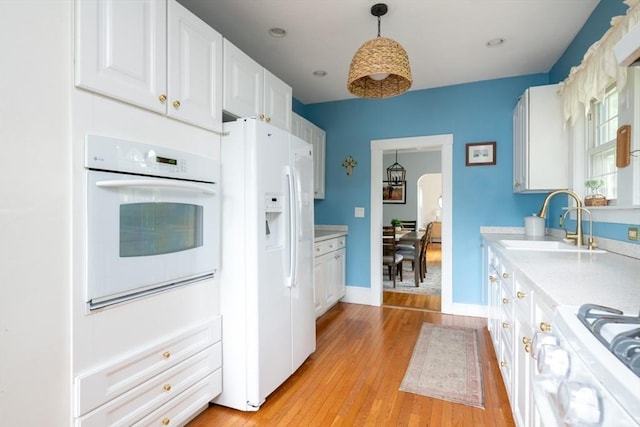136 Walnut St, Braintree, MA 02184 - kitchen featuring white appliances, light countertops, white cabinets, and light wood-style floors