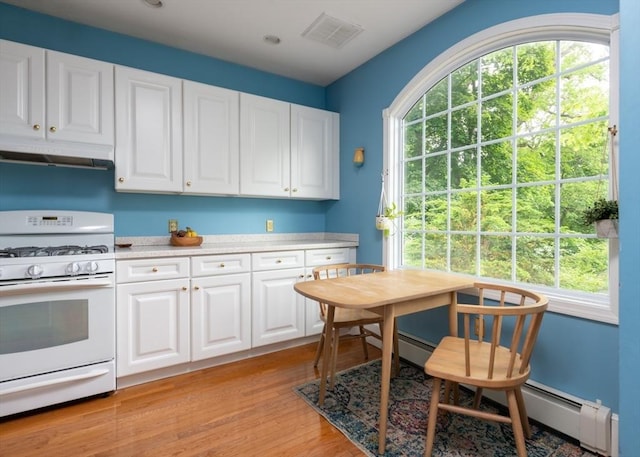 136 Walnut St, Braintree, MA 02184 - kitchen with white gas range, under cabinet range hood, light countertops, light wood-style flooring, and white cabinets