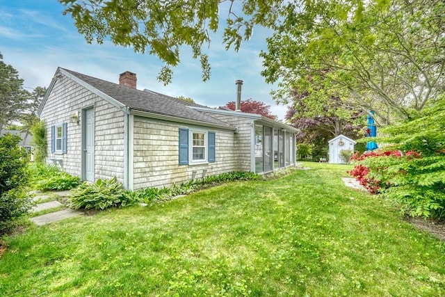 7 Burton Ave, Harwich, MA 02671 - view of side of home featuring a chimney, a lawn, a shingled roof, and a sunroom