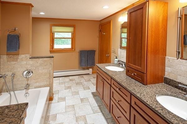 full bathroom with a baseboard radiator, a garden tub, double vanity, and recessed lighting