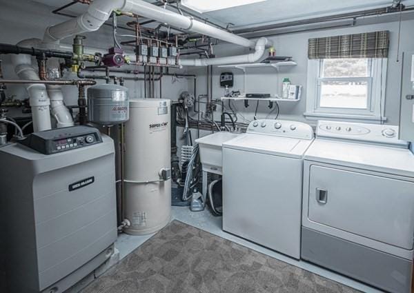 washroom with water heater and washer and clothes dryer