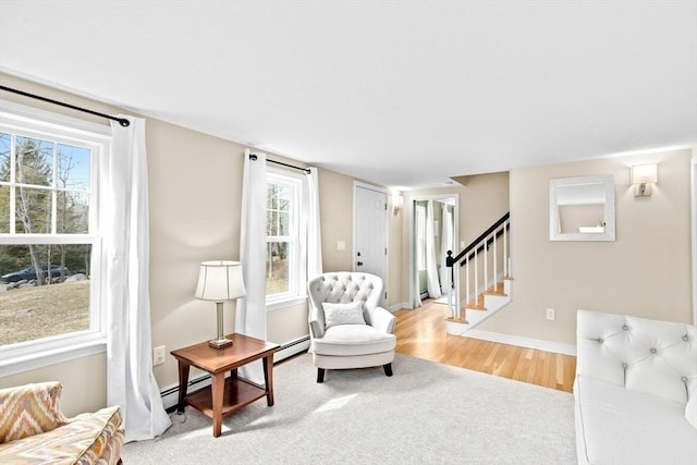 living area with light wood-style flooring, stairs, baseboards, and baseboard heating